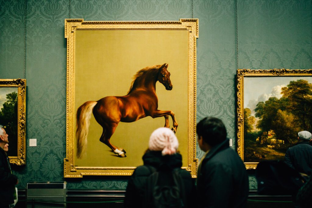 une personne qui regarde une peinture de cheval 